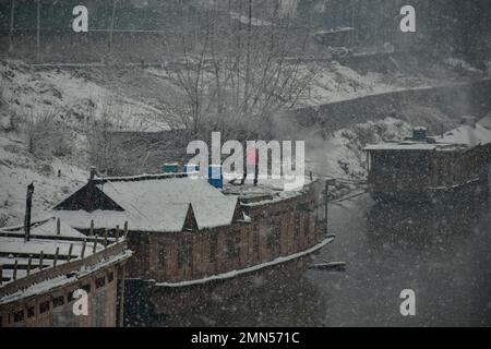 Srinagar, Indien. 30. Januar 2023. Ein Mann räumt während des Schneefalls in Srinagar Schnee von seinem Hausboot. Das Kaschmir-Tal war von der Außenwelt abgeschnitten, alle Flüge zum und vom Flughafen Srinagar wurden gestrichen und die Nationalautobahn wurde wegen starkem Schneefall am Montagmorgen gesperrt. (Foto: Saqib Majeed/SOPA Images/Sipa USA) Guthaben: SIPA USA/Alamy Live News Stockfoto