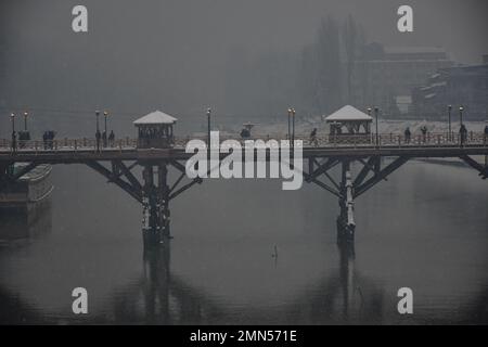 Srinagar, Indien. 30. Januar 2023. Die Bewohner laufen entlang der schneebedeckten Fußbrücke, während es in Srinagar schneit. Das Kaschmir-Tal war von der Außenwelt abgeschnitten, alle Flüge zum und vom Flughafen Srinagar wurden gestrichen und die Nationalautobahn wurde wegen starkem Schneefall am Montagmorgen gesperrt. (Foto: Saqib Majeed/SOPA Images/Sipa USA) Guthaben: SIPA USA/Alamy Live News Stockfoto