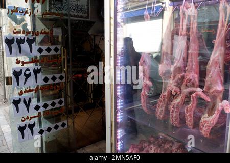 29. Januar 2023, Teheran, Teheran, Iran: Ein älterer iranischer Mann läuft am 29. Januar 2023 am Shapour Bazaar (Markt) im Süden Teherans, Iran, vorbei an einer Metzgerei. Seit Mitte September ist der Iran von Protesten gegen die Regierung erschüttert, die durch den Tod einer Frau ausgelöst wurden, die von der Moralpolizei des Landes inhaftiert wurde. Die Demonstrationen eskalierten schnell zu Forderungen nach einem Ende von mehr als vier Jahrzehnten der Geistlichen Herrschaft des Landes. (Kreditbild: © RouzbritFouladi/ZUMA Press Wire) NUR REDAKTIONELLE VERWENDUNG! Nicht für den kommerziellen GEBRAUCH! Stockfoto