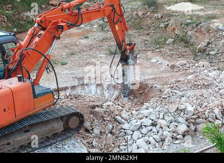 Nahaufnahme von einem schweren Baugewerbe bagger Maschine zerkleinern Steine in einer Baustelle Stockfoto