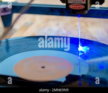 Lasergravierer, Laserverbrennung auf alten Schallplatten mit 33 U/min Stockfoto