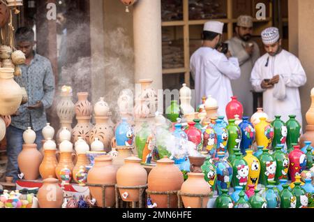 Nizwa, Oman, 2. Dezember 2022: Farbenfrohe Töpfe werden auf dem traditionellen Nizwa-Markt angeboten Stockfoto