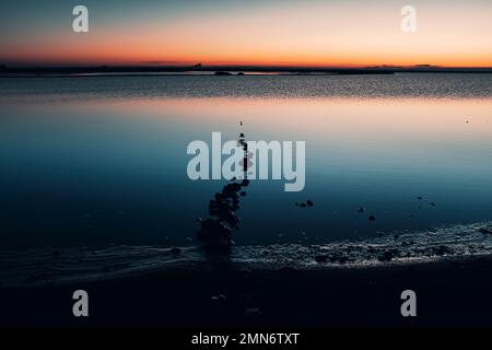 Neblige Seenlandschaft - ruhige Wasseroberfläche des Sees reflektiert lila Himmel mit rosa und blauen Wolken nach Sonnenuntergang. Weiße Nächte Saison in der Republik Kare Stockfoto