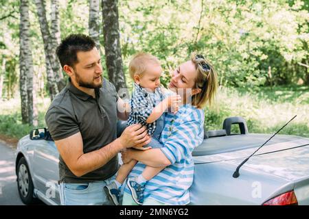 Mama, Papa und kleiner Sohn in einem Cabriolet. Sommer Familienausflug in die Natur Stockfoto