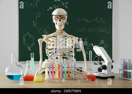 Skelett und verschiedene Chemieglasgeräte im Klassenzimmer Stockfoto