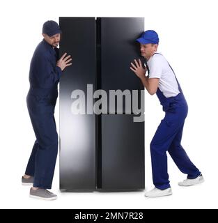Professionelle Arbeiter, die Kühlschränke auf weißem Hintergrund tragen Stockfoto