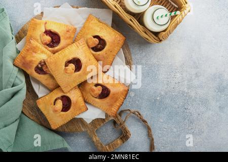 Valentinstag herzförmige Handkuchen. Mini-Blätterteig oder Handkuchen gefüllt mit Apfel und streuen Sie Zuckerpulver auf den Teller. Eine Idee für hausgemachte Romantiker Stockfoto