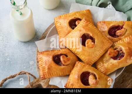 Valentinstag herzförmige Handkuchen. Mini-Blätterteig oder Handkuchen gefüllt mit Apfel und streuen Sie Zuckerpulver auf den Teller. Eine Idee für hausgemachte Romantiker Stockfoto