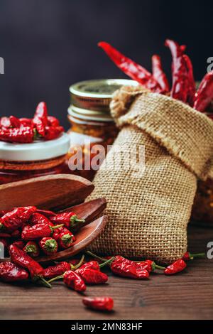 Verschiedene Arten von roten, heißen Chili-Paprika. Hausgemacht und in Glasgefäßen für Konfitüren gelagert Stockfoto