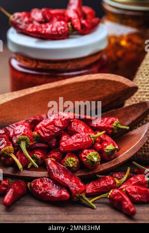 Verschiedene Arten von roten, heißen Chili-Paprika. Hausgemacht und in Glasgefäßen für Konfitüren gelagert Stockfoto