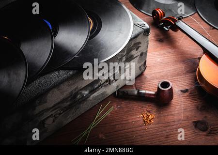 Geige, Schallplatten und Pfeife auf Holz Stockfoto