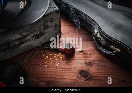 Geige, Schallplatten und Pfeife auf Holz Stockfoto