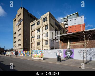 R&W Paul Silo, Ipswich, Suffolk, England - 30. Januar 2023: Verfallene Gebäude am Wasser, die umgebaut werden müssen, mit Cardinal Lofts Apartments in Backgr Stockfoto