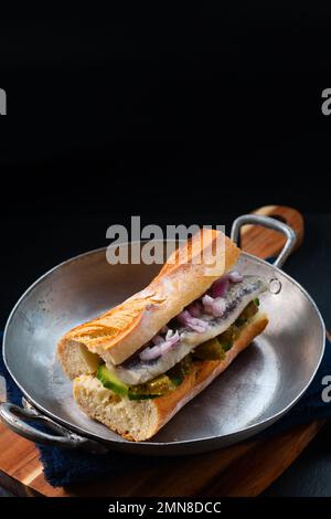 Hering-Sandwich mit Lebensmittelkonzept auf schwarzem Hintergrund und Kopierraum Stockfoto