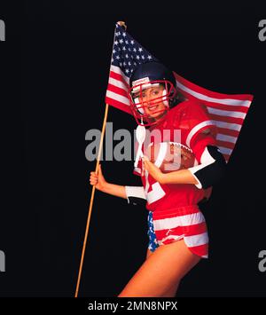 Junge Frau, amerikanische Fußballspielerin, die die US-Flagge trägt. Stockfoto