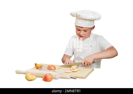 Ein Junge in weißer Koch-Kleidung kocht in einer Küche zu Hause, isoliert auf weißem Hintergrund Stockfoto