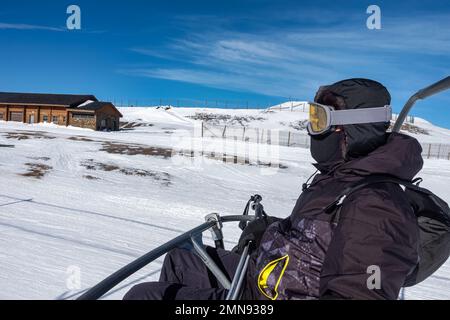 Skifahrer sitzen auf einem Sessellift, der Sie auf den Gipfel des Berges bringt, um Ski zu fahren, Andorra, Grandvalira. Stockfoto