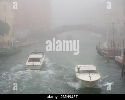 Boote, die an einem nebligen Tag in Venedig segeln. Transport- und Wetterkonzept. Stockfoto