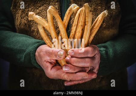 Gebackene und gekochte herzhafte Taralli-Snacks, typisches italienisches Apulien-Gebäck in Frauenhänden. Stockfoto