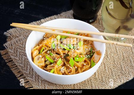 Nudeln mit Gemüse, Huhn und Pilzen in der Schüssel. Gebratene Pasta umrühren Stockfoto