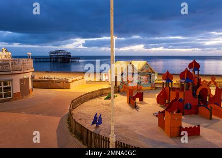 Abend an der Brighton Seafront, East Sussex, England. West Pier ist in der Ferne ruiniert. Stockfoto