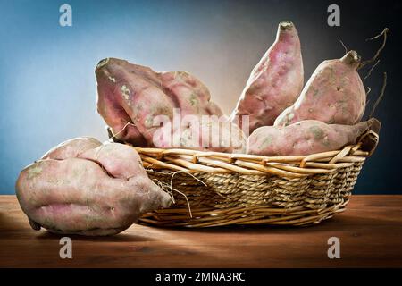 Süße rote Kartoffelknollen in einem Holzkorb Stockfoto