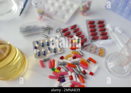 Viele verschiedene medizinische Pillen und Medikamente mit Flaschen auf dem Labortisch, Draufsicht. Stockfoto