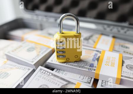 Gelbes Vorhängeschloss mit Kombination auf vielen Stapeln US-Dollar Nahaufnahme. Stockfoto