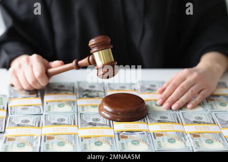 Richter mit hölzernem Hammer und einer Menge Dollarscheine aus der Nähe. Stockfoto