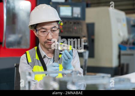 Ingenieure tragen Schutzanzüge mit Helmen, die im Werk arbeiten Stockfoto