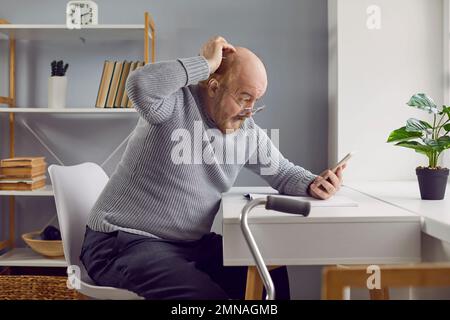 Ein älterer Mann verwirrt sich, wenn er eine Anwendung auf seinem modernen Mobiltelefon verwendet Stockfoto