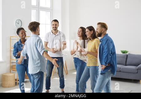 Freudige, aufgeregte Menschen hören interessante, aufregende und lustige Geschichten über ihren männlichen Freund. Stockfoto