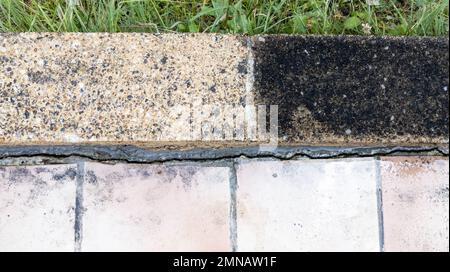 Gehweg gepflasterte Fußbodenplatten sind nach einer Anti-Schaum-Reinigung halb sauber und verschmutzt Stockfoto