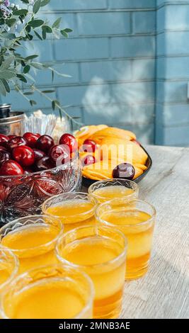 Gläser Cocktails an der Bar. Gläser Sekt mit rotem Alkohol. Preraring aperol Spritz Cocktail in der Sommerbar im Freien Stockfoto