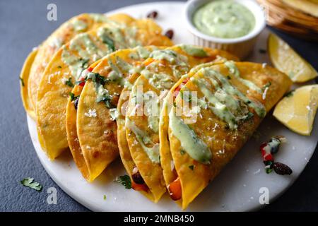 Knusprig gebratener Reis und Bohnen Tacos | Vorspeise für den Spieltag serviert mit Avacado-Sahne-Sauce Stockfoto