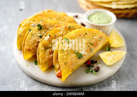 Knusprig gebratener Reis und Bohnen Tacos | Vorspeise für den Spieltag serviert mit Avacado-Sahne-Sauce Stockfoto