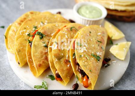 Knusprig gebratener Reis und Bohnen Tacos | Vorspeise für den Spieltag serviert mit Avacado-Sahne-Sauce Stockfoto