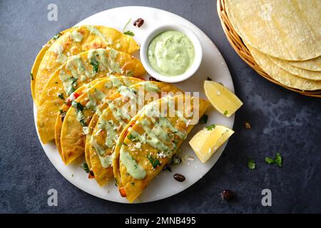 Knusprig gebratener Reis und Bohnen Tacos | Vorspeise für den Spieltag serviert mit Avacado-Sahne-Sauce Stockfoto