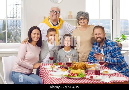 Portrait einer glücklichen Familie von drei Generationen, die gemeinsam Thanksgiving feiern. Stockfoto