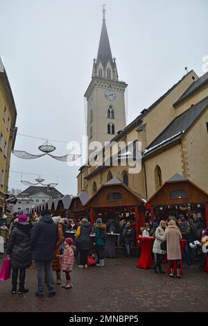 Villach, Osterreich - Dezember 24 2022. Weihnachtsmarkt an der Hauptplatz Straße an einem leicht nebeligen Heiligabend im historischen Zentrum von Villach Stockfoto