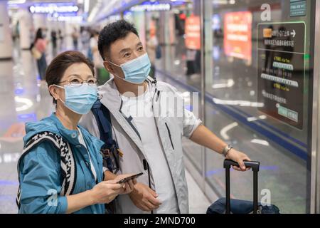 Glückliches älteres Paar, das eine Gesichtsmaske in der U-Bahn-Station trägt Stockfoto