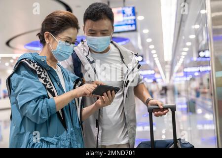 Glückliches älteres Paar, das eine Gesichtsmaske in der U-Bahn-Station trägt Stockfoto