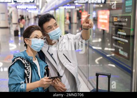 Glückliches älteres Paar, das eine Gesichtsmaske in der U-Bahn-Station trägt Stockfoto