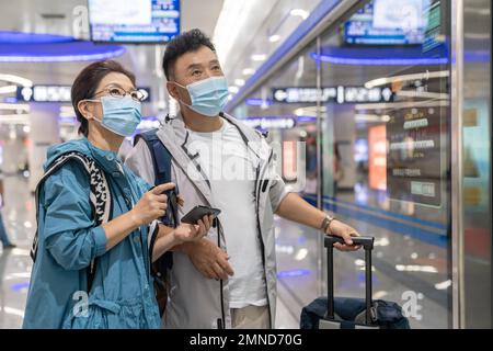 Glückliches älteres Paar, das eine Gesichtsmaske in der U-Bahn-Station trägt Stockfoto