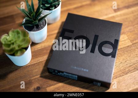 Samsung Galaxy Z Fold 4 in grau-grüner Farbe. Das Gerät befindet sich in der geöffneten Position. Originalverpackung auf den s Stockfoto