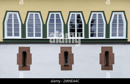 Reihe von Trapezfenstern über drei sehr schmalen Fenstern mit Steinrahmen Stockfoto
