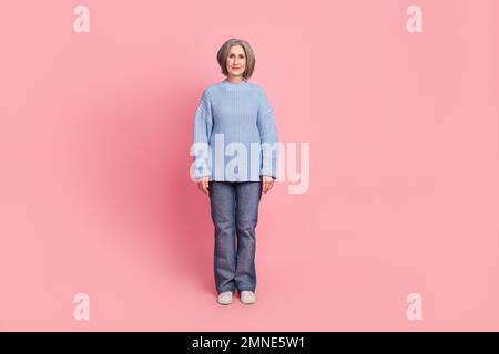 Ganzkörper-Fotokadre einer älteren Großmutter im Alter mit legerer blauer Pullover-Jeans Promo isoliert auf pinkfarbenem Hintergrund Stockfoto