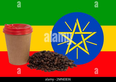 Tasse und eine Handvoll gerösteter Kaffeebohnen vor dem Hintergrund der äthiopischen Flagge. Der größte Kaffeeexporteur der Welt. Äthiopischer Kaffee Stockfoto