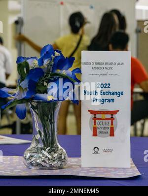 Am 2. Oktober 2022 in Camp Lester, Okinawa, Japan, wird ein Prospekt für das Jugendaustauschprogramm 2022 in Camp Lester Middle School ausgestellt. Das Programm wurde vom Ministerium für auswärtige Angelegenheiten und dem Ministerium für Verteidigungsbildung organisiert und ermöglichte Teilnehmern aus Japan und den USA, gesunde Kommunikationsfähigkeiten zu üben und an Aktivitäten teilzunehmen, um mehr über die Kulturen der anderen zu erfahren. Die Studenten schufen kulturell gemeinsame Maskottchen, erhielten Auszeichnungen und etablierten dauerhafte Freundschaften. Stockfoto