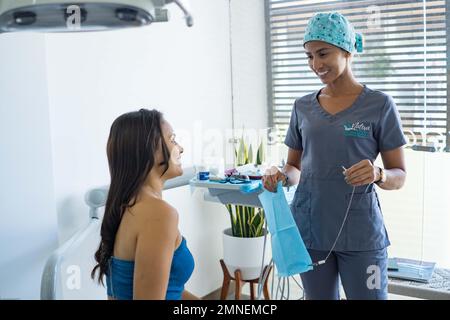 Weibliche Zahnarzt in der Zahnarztpraxis im Gespräch mit weiblichen Patienten und Vorbereitung der Behandlung. Stockfoto